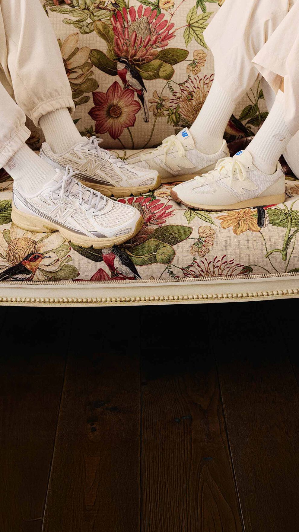 Two models sitting on a couch wearing the 471 and 740 shoes.