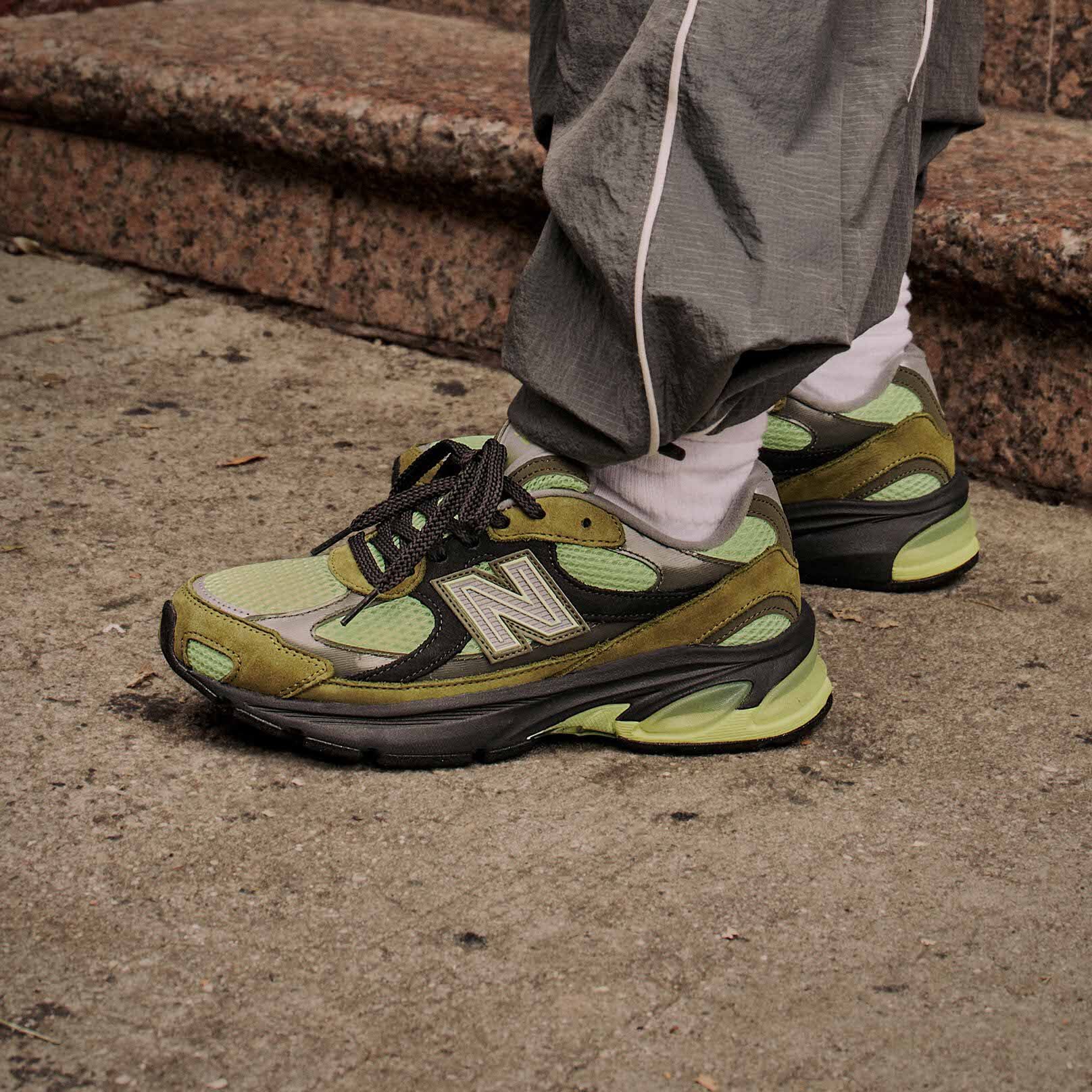   Side profile on figure shot of green, brown and black sneakers.