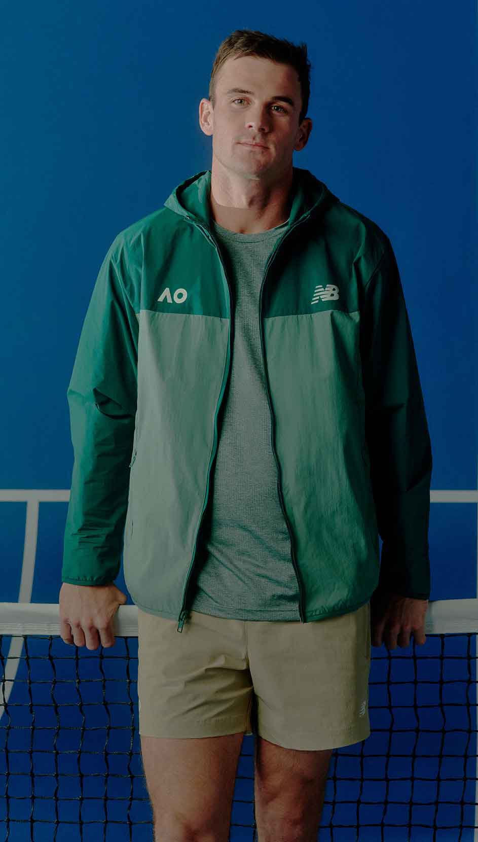 Tennis player Tommy Paul standing in front of a tennis court. 