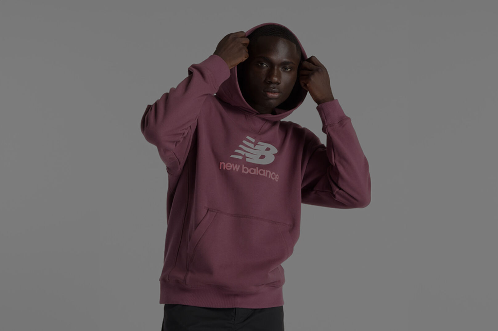 Man wearing maroon New Balance sweatshirt.
