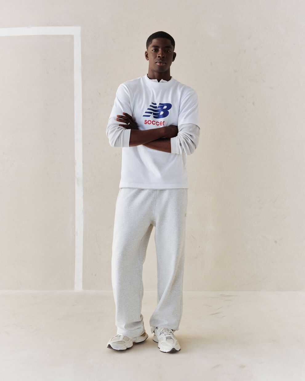 A person wearing a white soccer graphic tee.