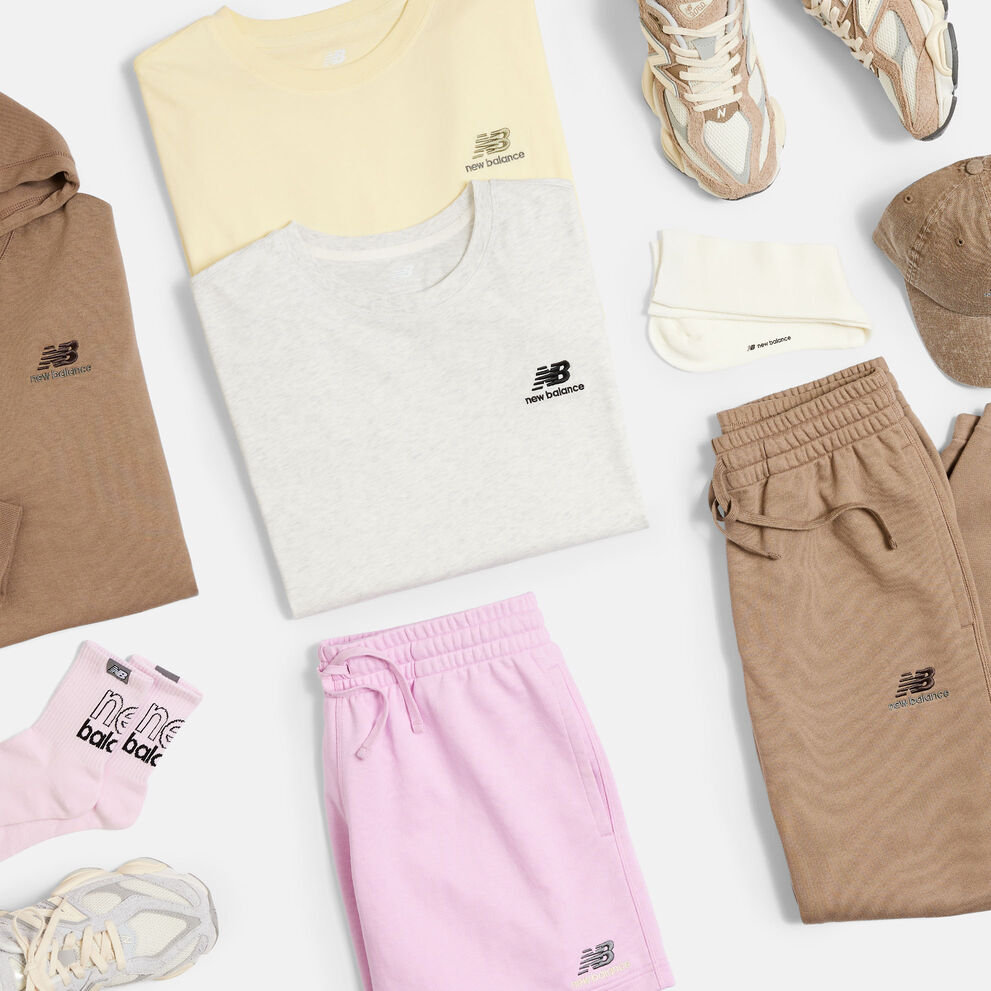 Overhead view of an assortment of folded NB Uni-ssentials apparel and sneakers 