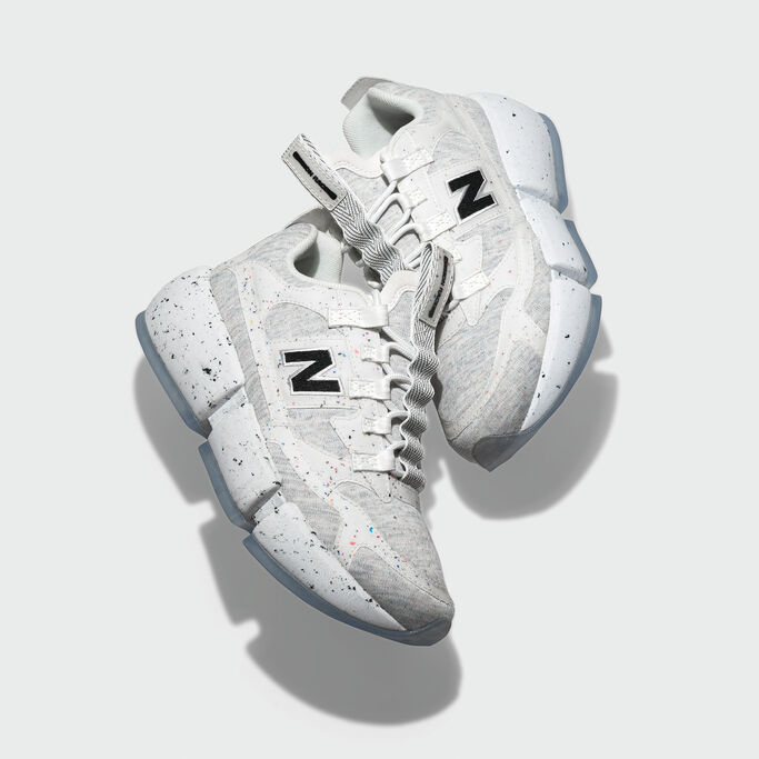 Pair of Vision Racer shoes cradled against grey studio background