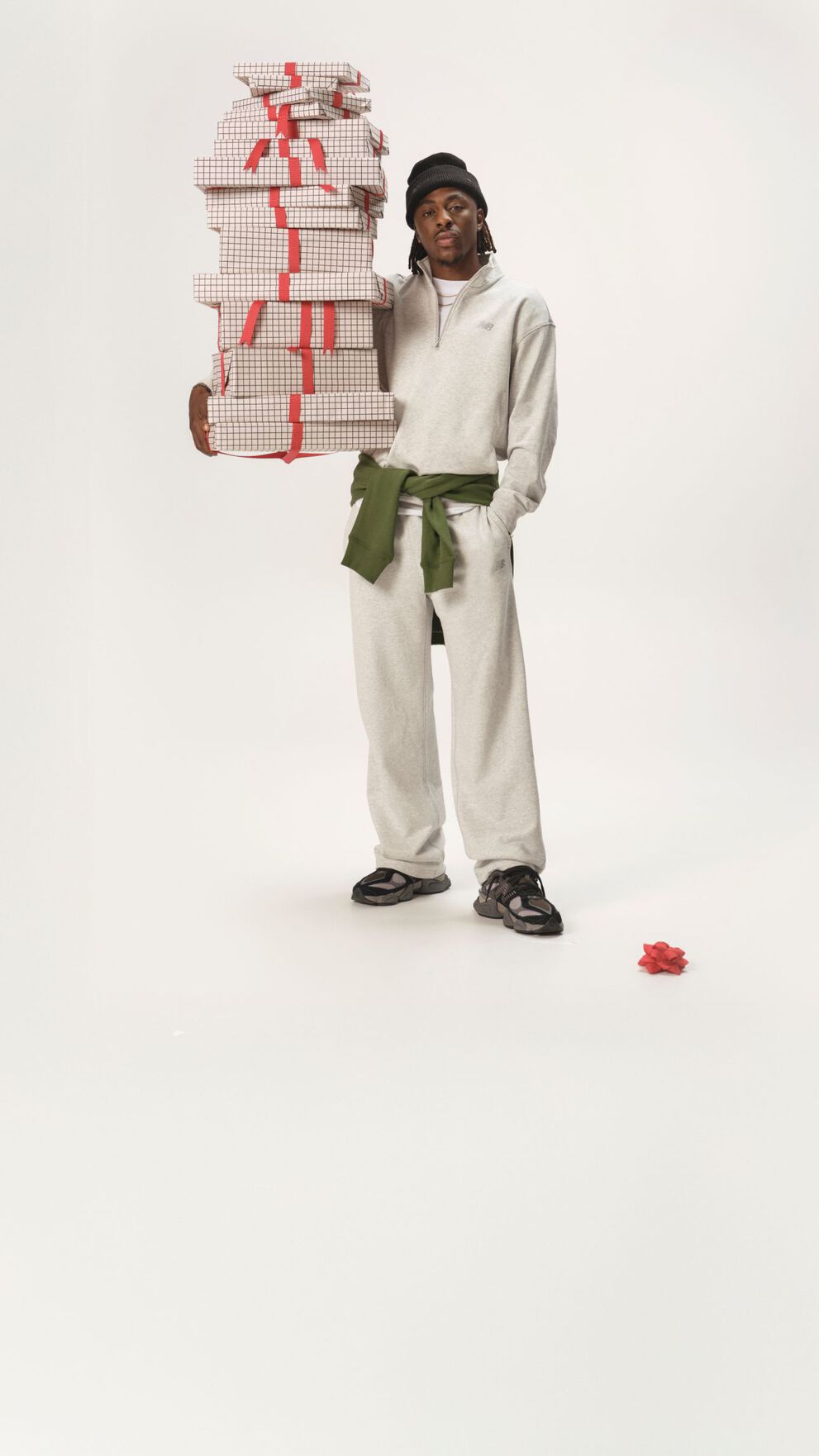 Soccer athlete standing in a white matching set holding gifts.
