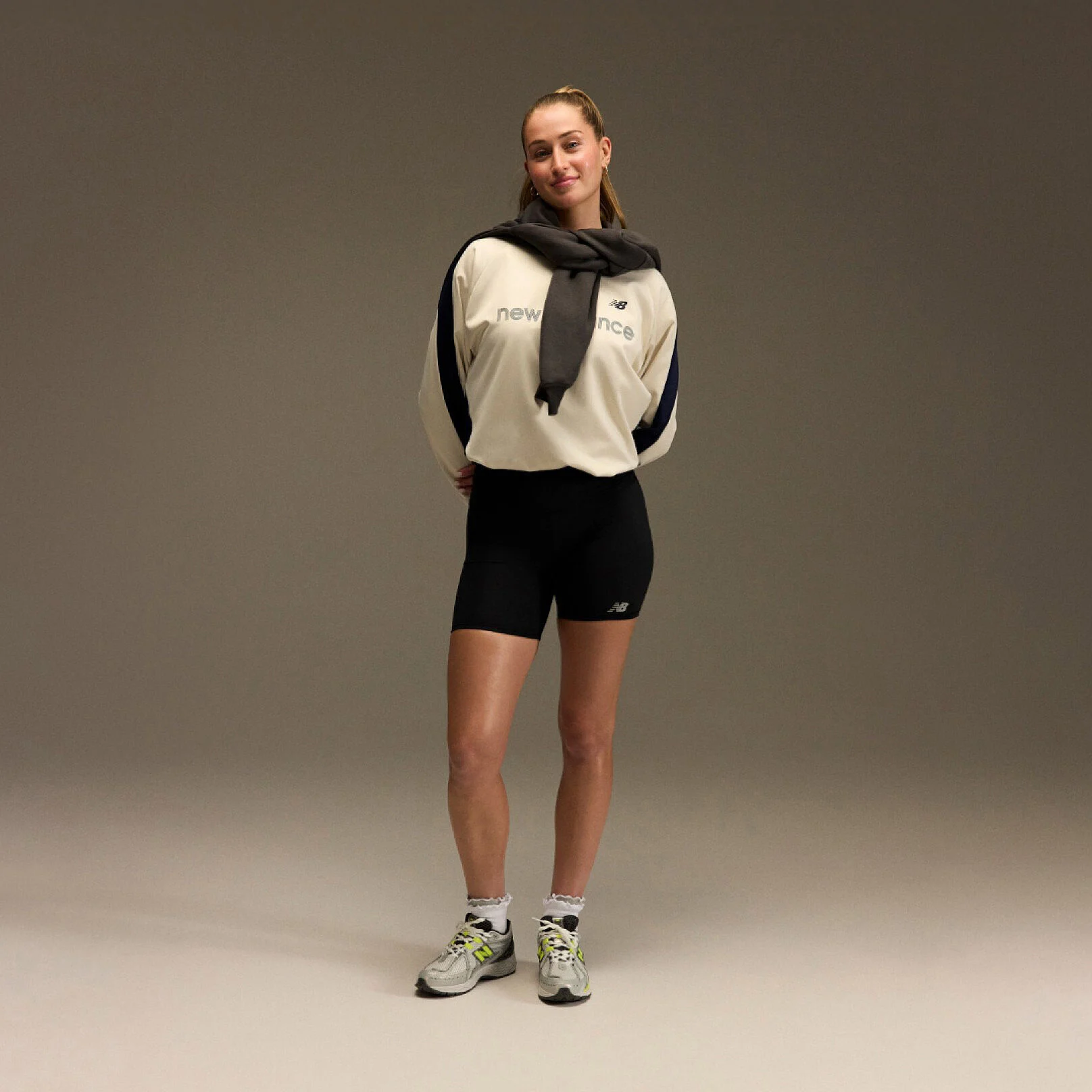 Jordyn Huitema standing with an athletic outfit in front of a brown and tan background.