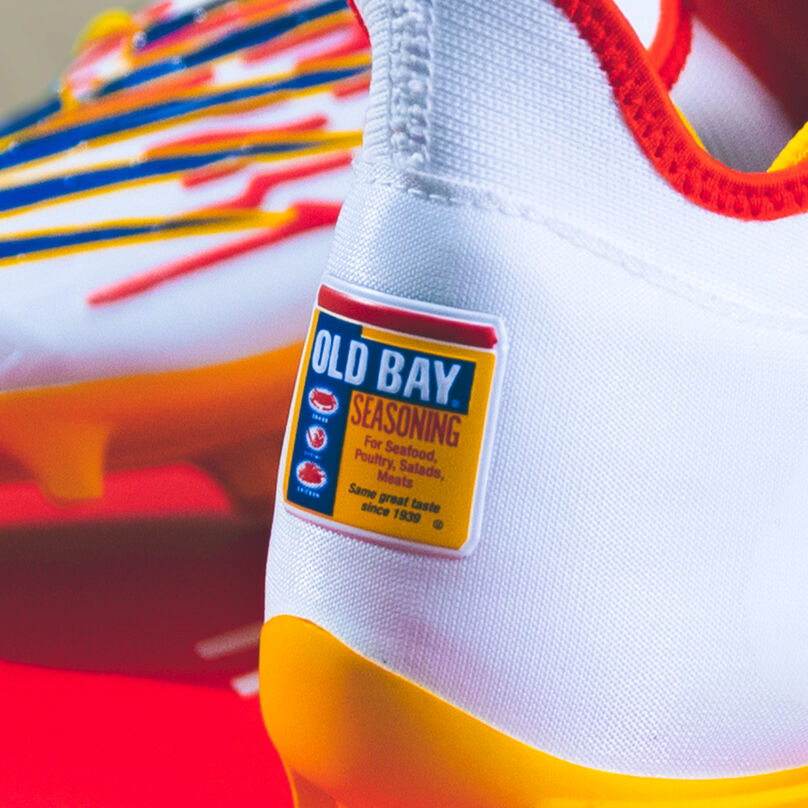 OLD BAY logo on the back of a white lacrosse cleat.