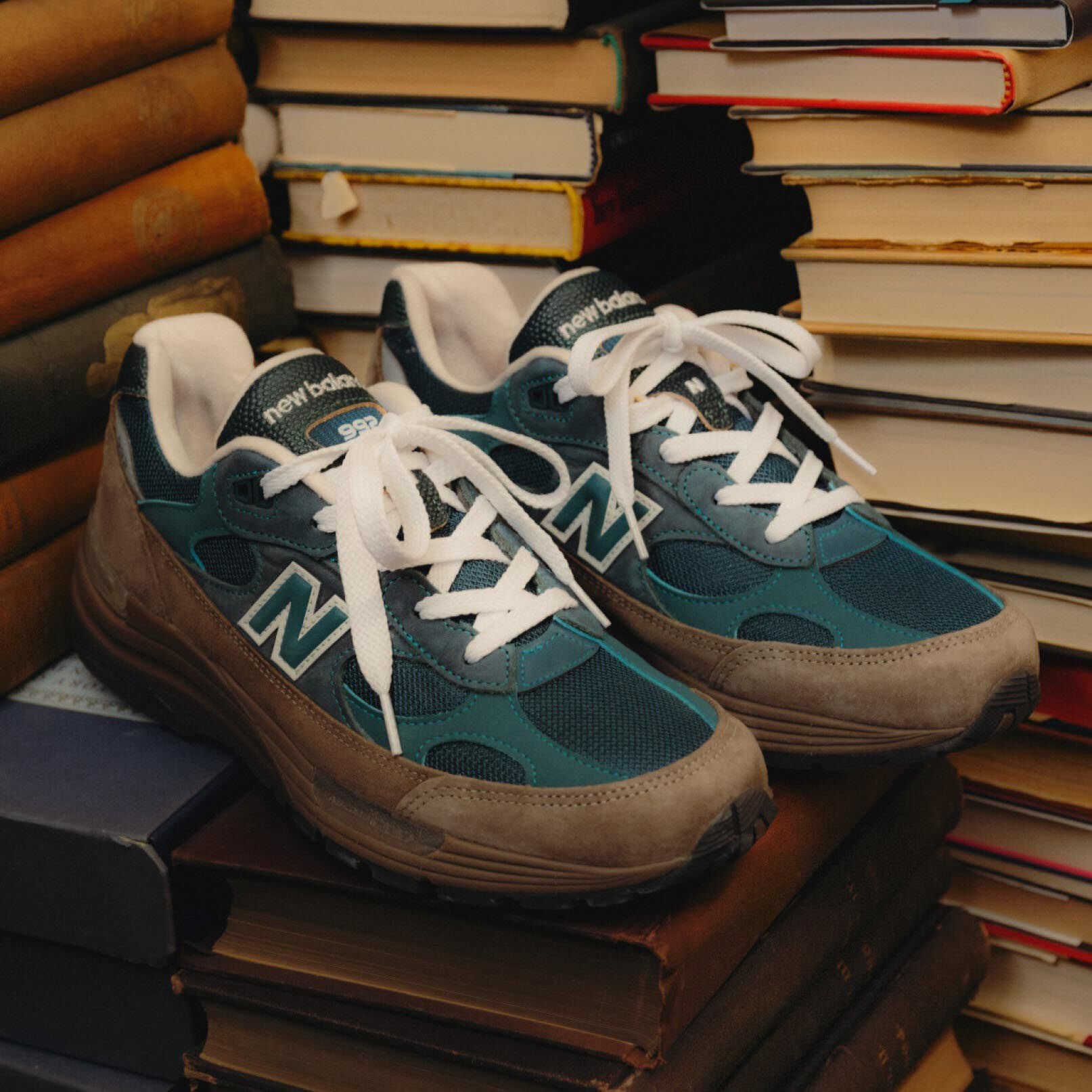 Green and brown shoes sitting on a pile of books