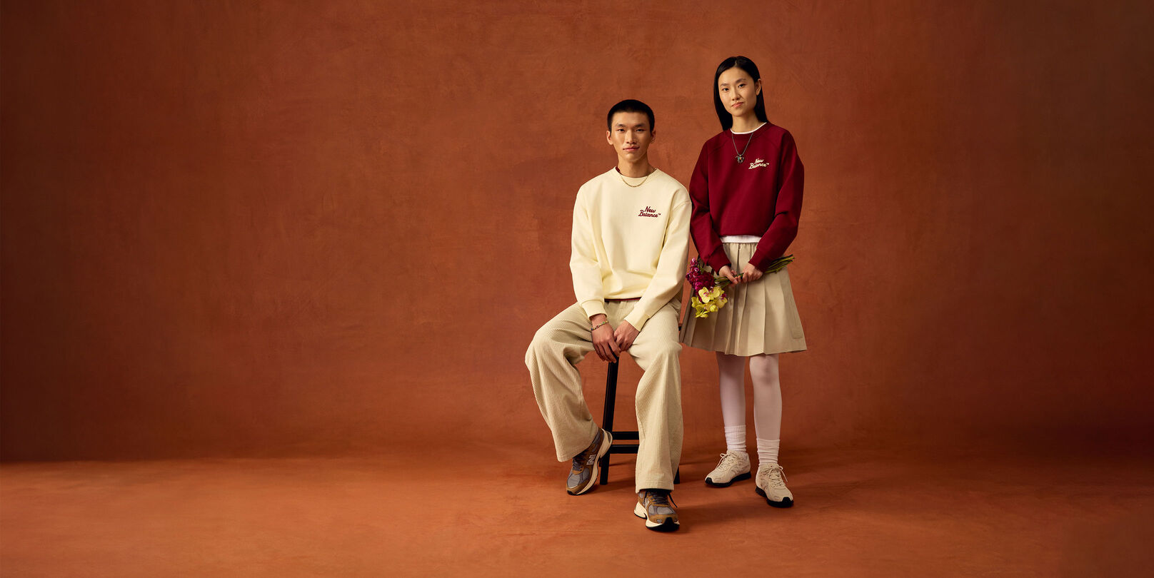 Man sitting on a stool and woman standing up.
