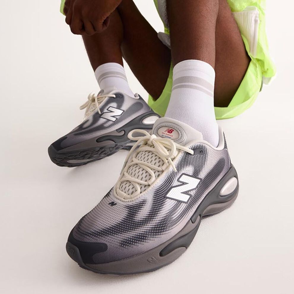Knee down angle of a person wearing grey AC Runner shoes.