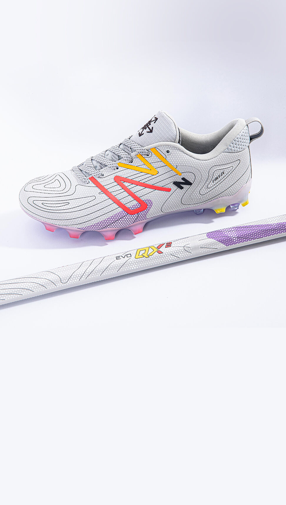 White lax cleat sitting on a grey background with a matching stick.