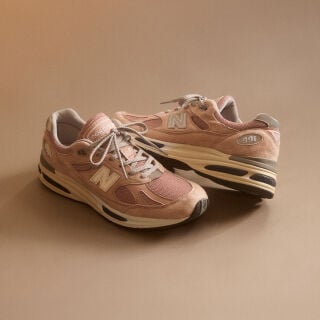 A pair of&nbsp;New Balance Made in UK sneakers in a beige studio environment.