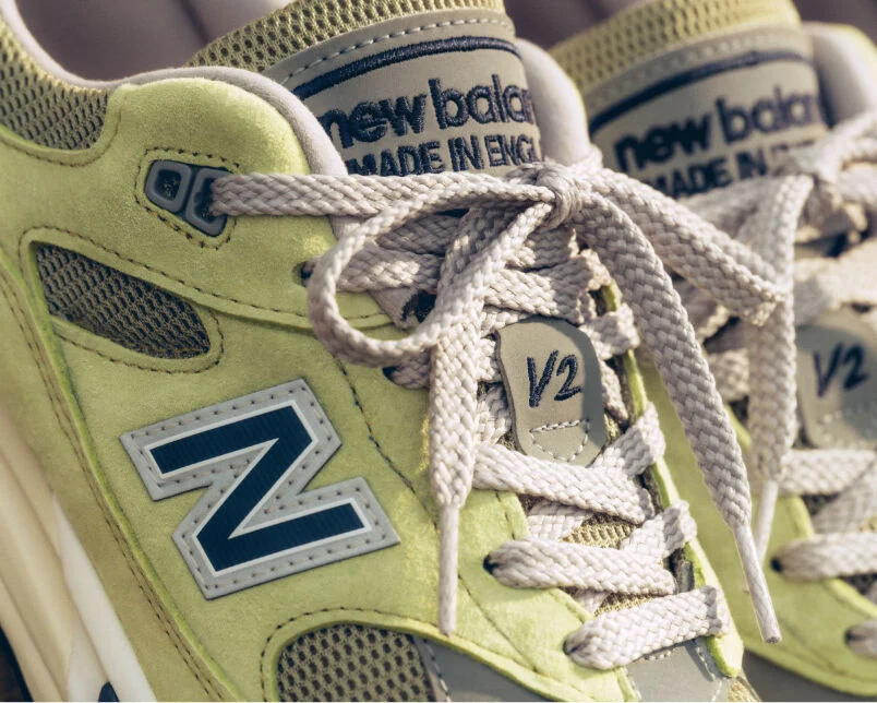 A pair of&nbsp;New Balance Made in UK sneakers in a beige studio environment.