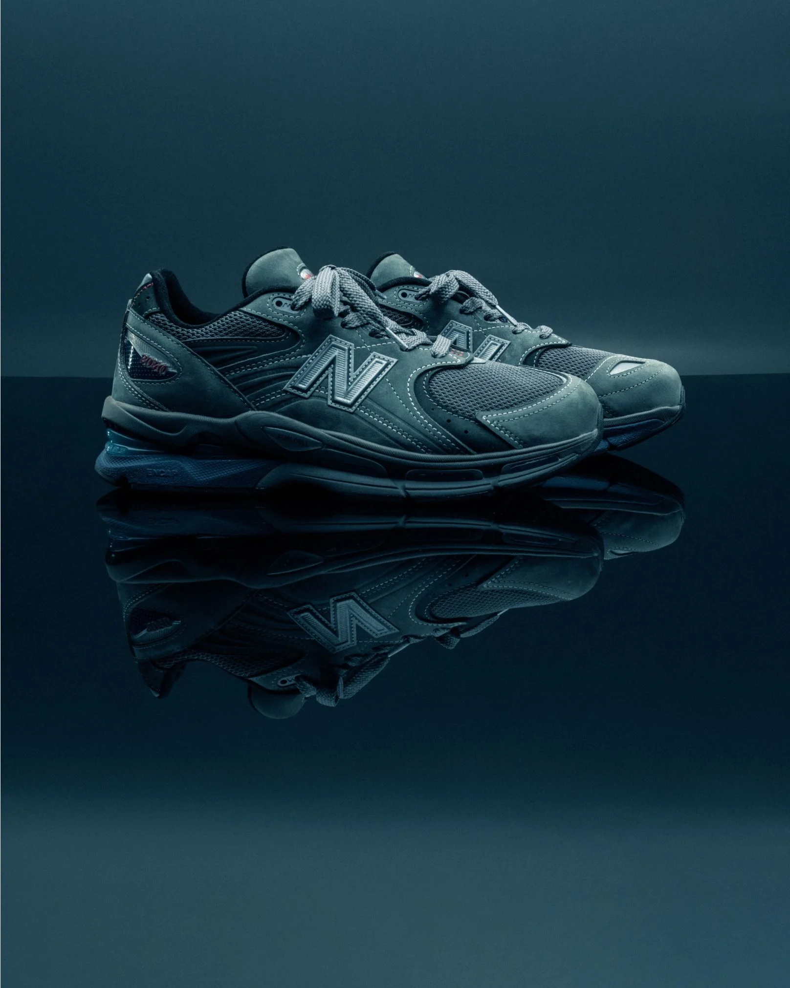 A pair of dark shoes sitting in a green studio environment.