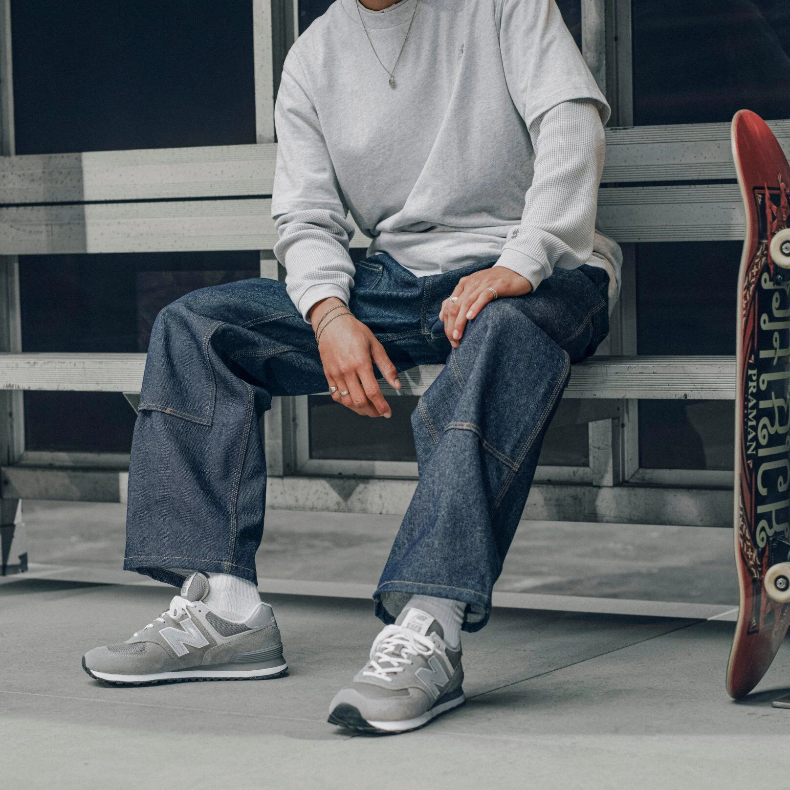 Knee down image of a person wearing a pair of grey 574