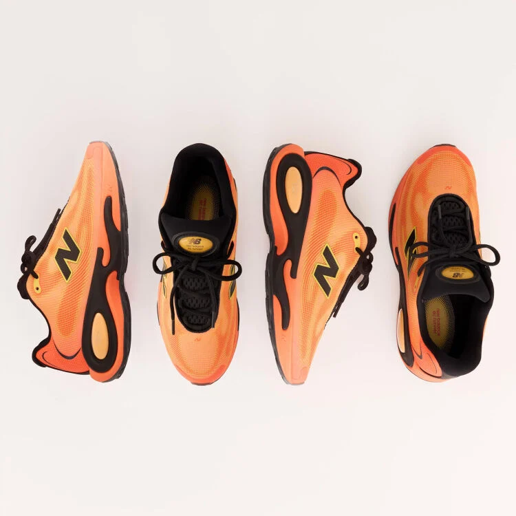 Two pairs of orange AC Runner shoes on a grey background.