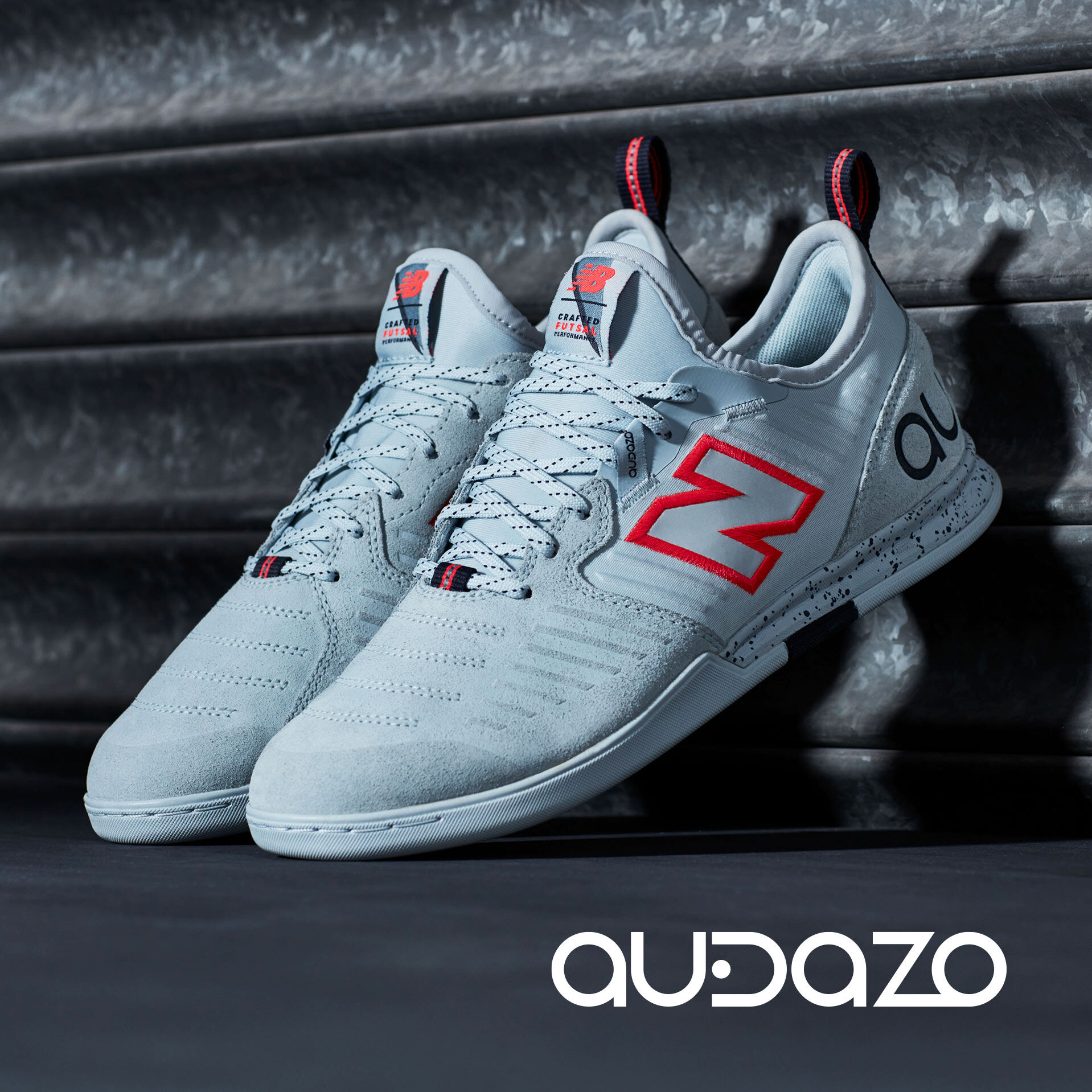 Pair of grey and red Audazo propped against wall with Audazo logo.