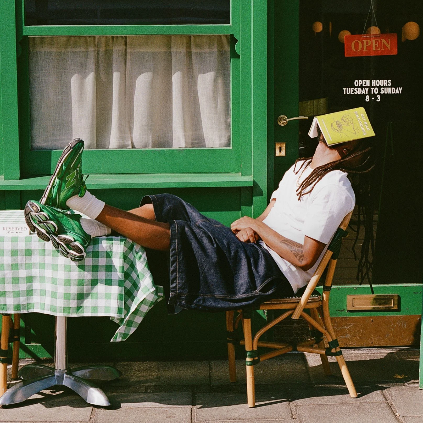 Aminé wearing the ABZORB 2000 ‘Biblioteca’ shoes in front of a cafe. 