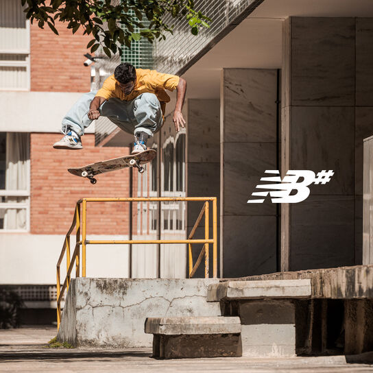 Numeric logo on image of skateboarder Tiago Lemos in midair over his board wearing his signature model Numeric 1010 shoes