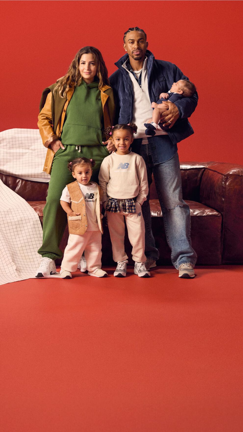Family gathered around a red couch on a red background.