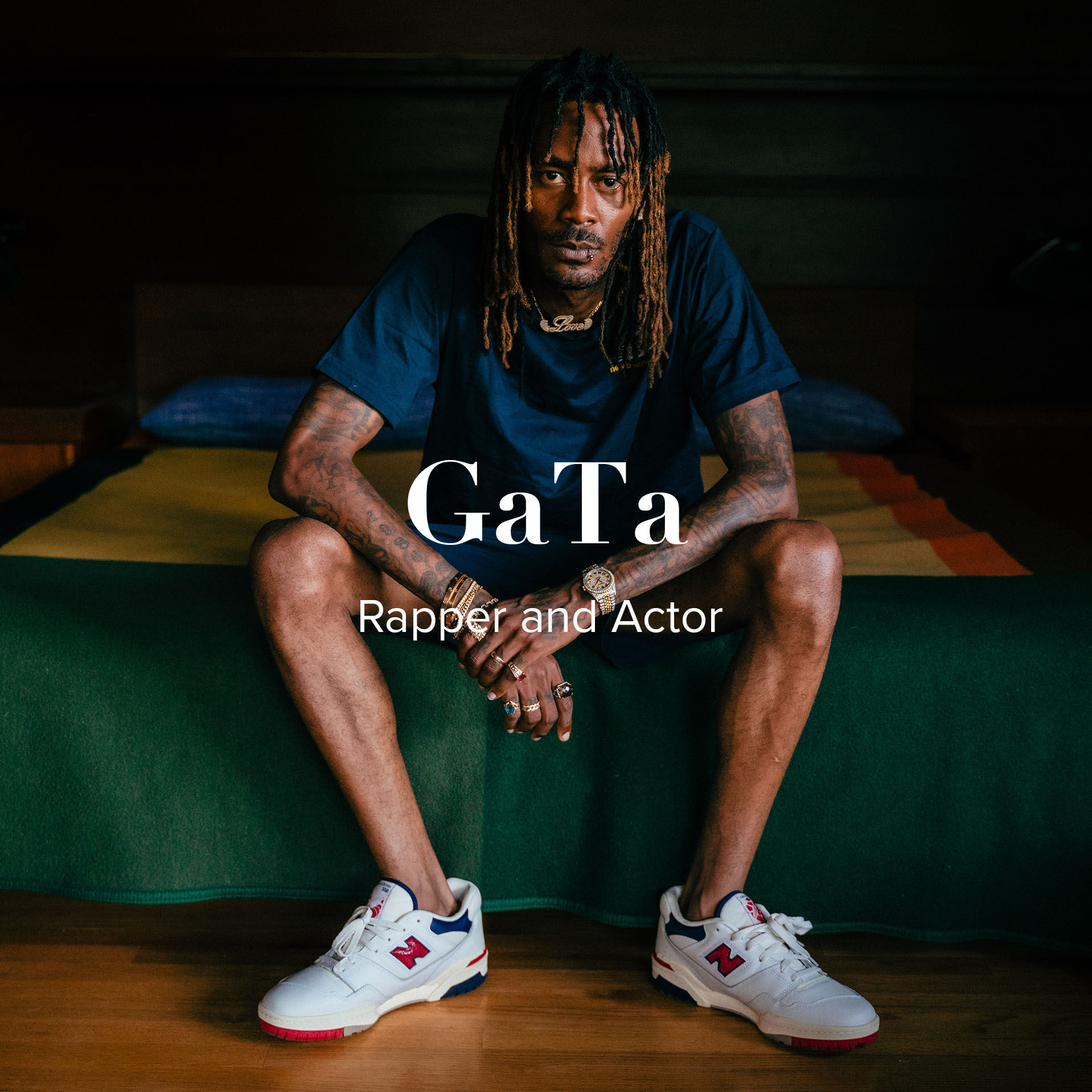 GaTa – actor, rapper, and mental health advocate – sitting on a bed in a dark room