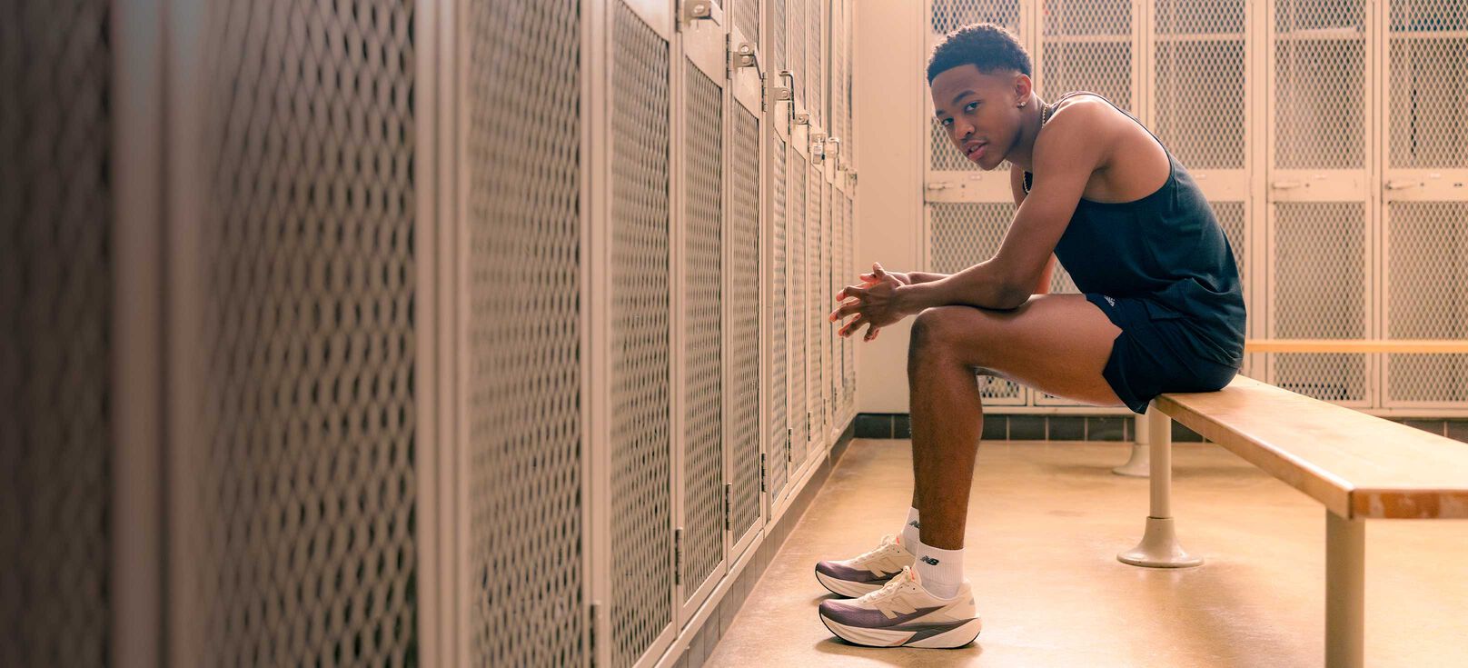 Quincy Wilson sitting on a bench in a locker room