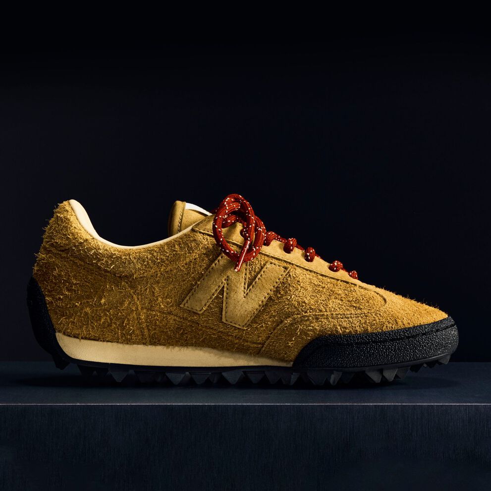 A brown suede Gator Run shoe on a black background.