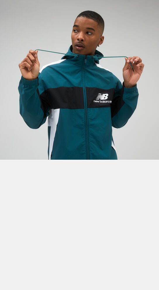 Man wearing black and green NB jacket posed against studio background