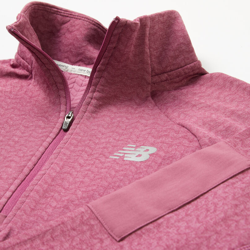 Pink women’s jacket laying on a grey background focusing on the collar.