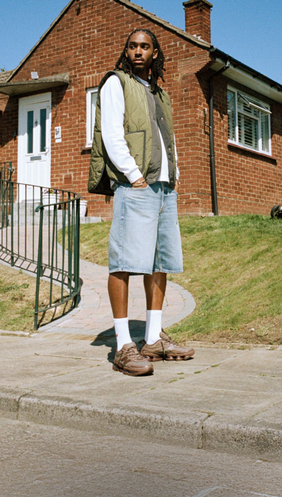 Imagen de rodillas de alguien usando zapatillas New Balance grises al aire libre.