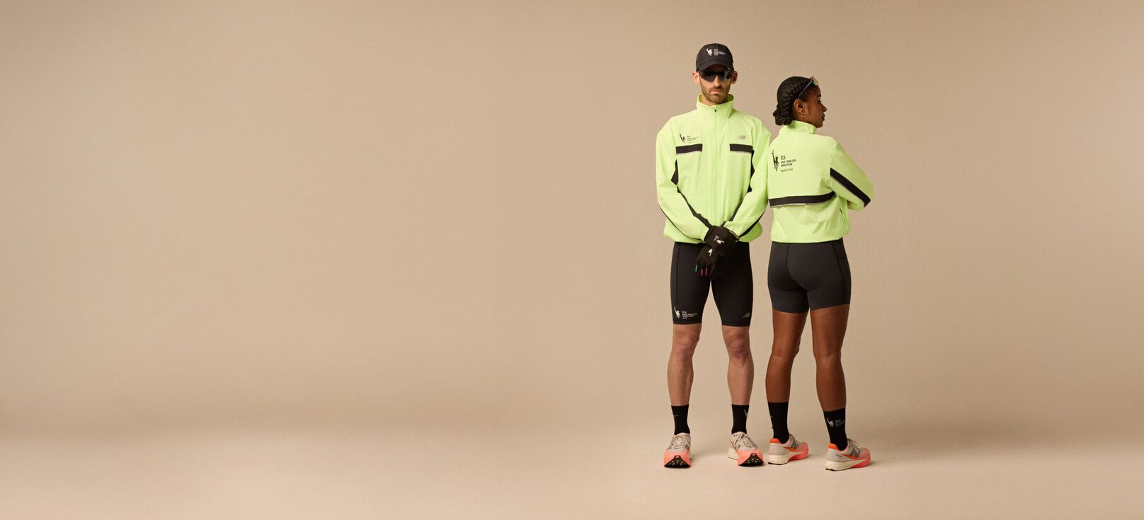 A man and woman wearing neon yellow jacket and running apparel in front of a beige background.