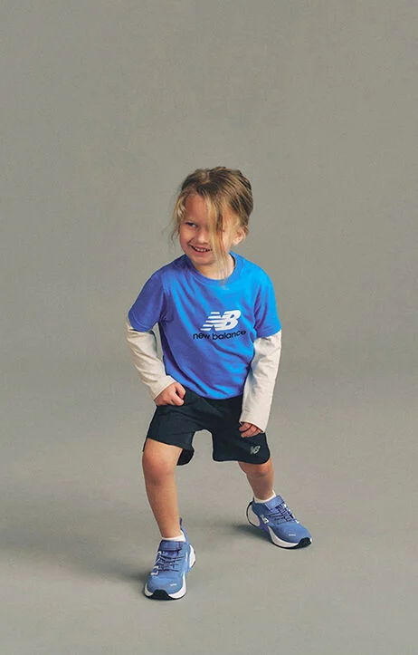 Kid stretching against a grey studio background.