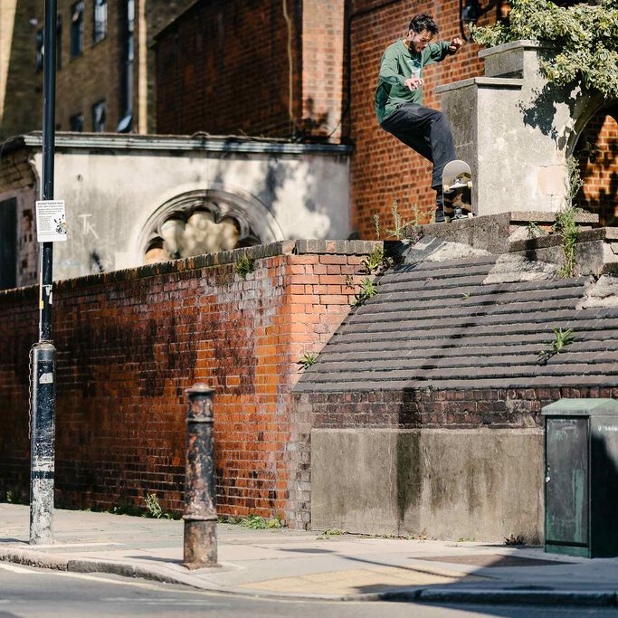 Pro skateboarder Tom Knox performing a jump on a concrete wall.