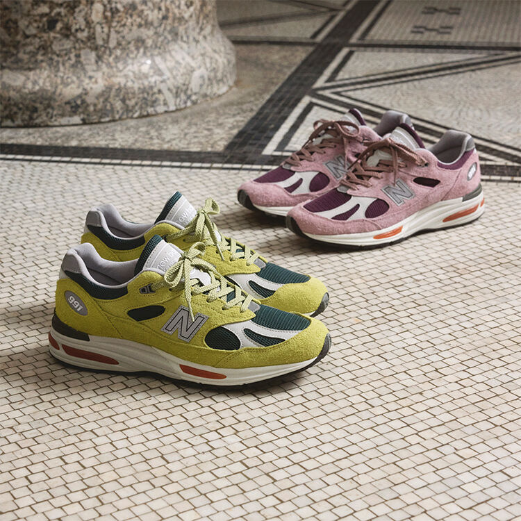 Dos pares de zapatillas New Balance Made in UK sobre un suelo de baldosas blancas texturizadas.  