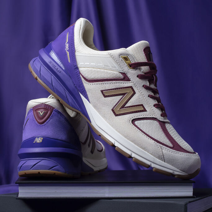 Black History Month exclusive 990 pair sitting on black books with velvet background.