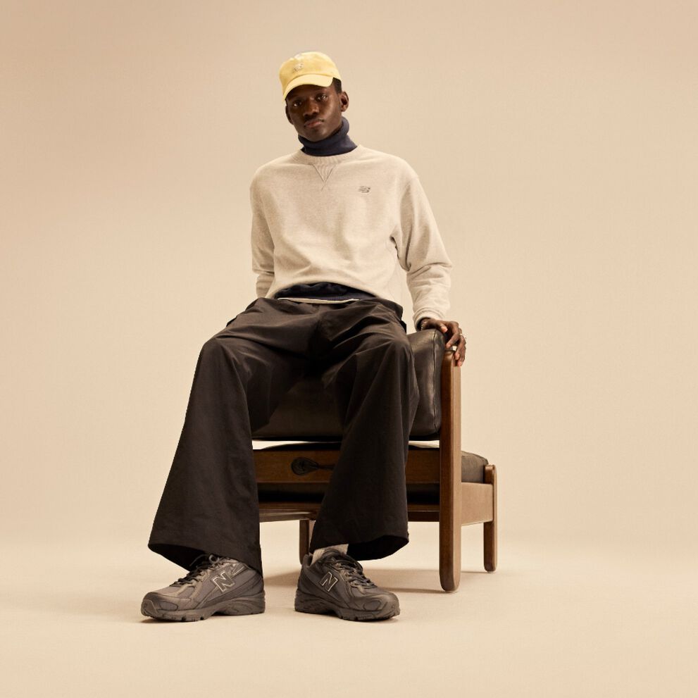 A man sitting in a chair with a beige background.