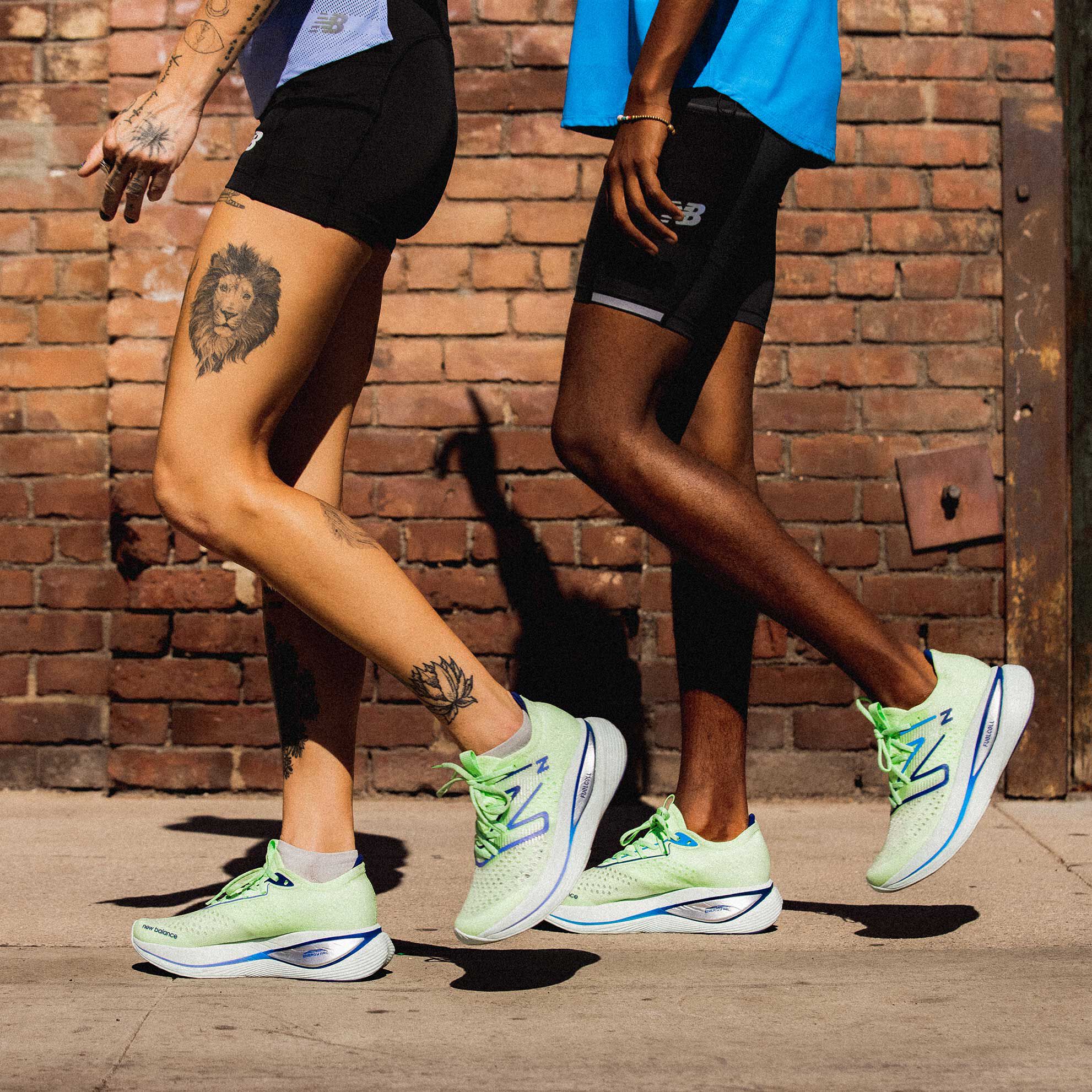 Feet of man and woman walking on sidewalk wearing Fuelcell SuperComp Trainer v1