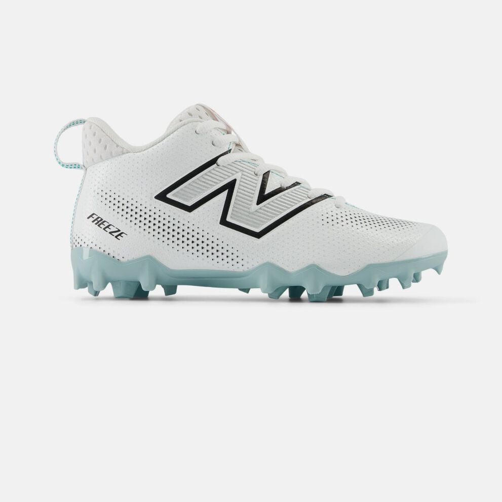 Side profile of a white New Balance lacrosse cleat on a white background, featuring a perforated synthetic upper, black‑outlined &ldquo;N&rdquo; logo, mid‑cut ankle collar, molded teal studs for field traction, and &ldquo;FREEZE&rdquo; text near the heel. 