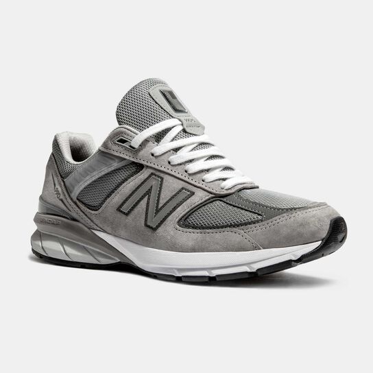Single grey 990 sneaker on grey background 