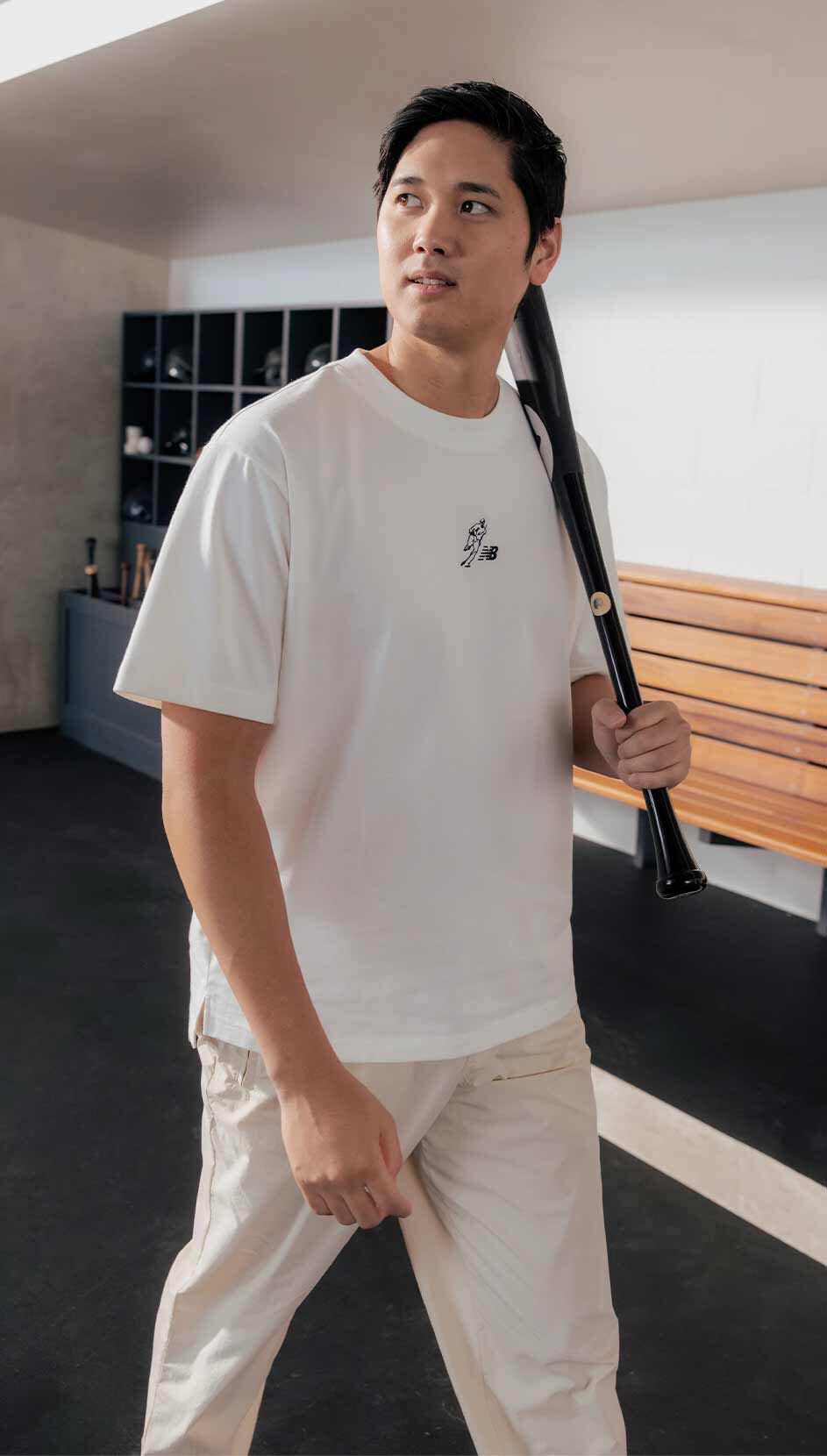 Shohei Ohtani standing with a baseball bat wearing New Balance apparel. 