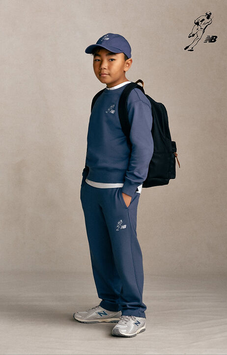 Kid standing against a grey studio background.