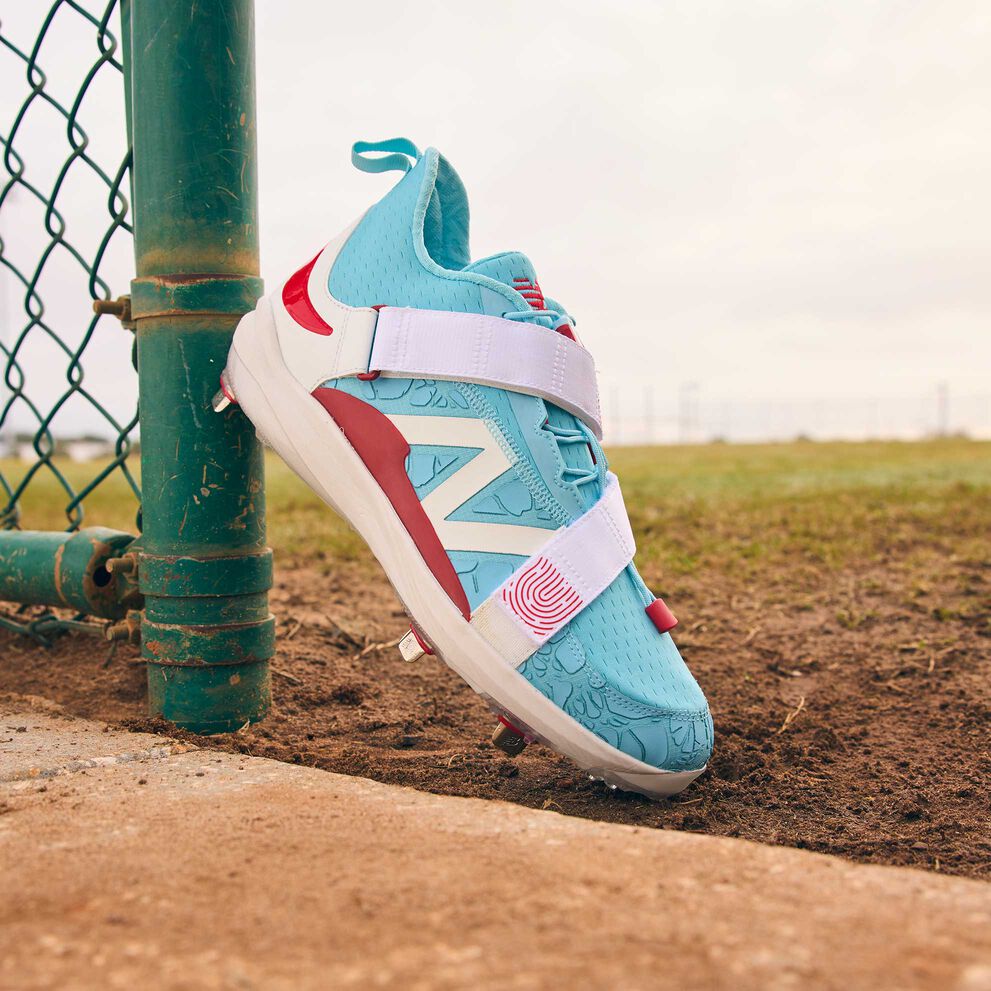 A FuelCell Lindor 2 ‘Vintage Puerto Rico’ cleat sitting on a turf and dirt field. 