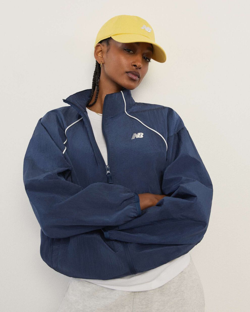 A woman standing in front a white wall.