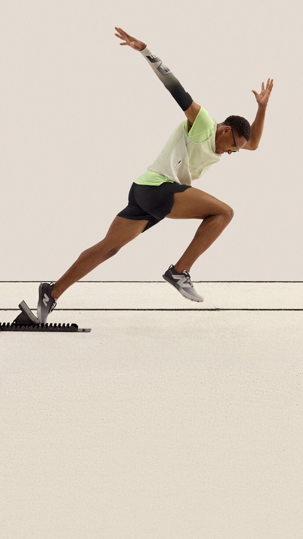 A sprinter is captured mid-stride launching from starting blocks on a track. 
