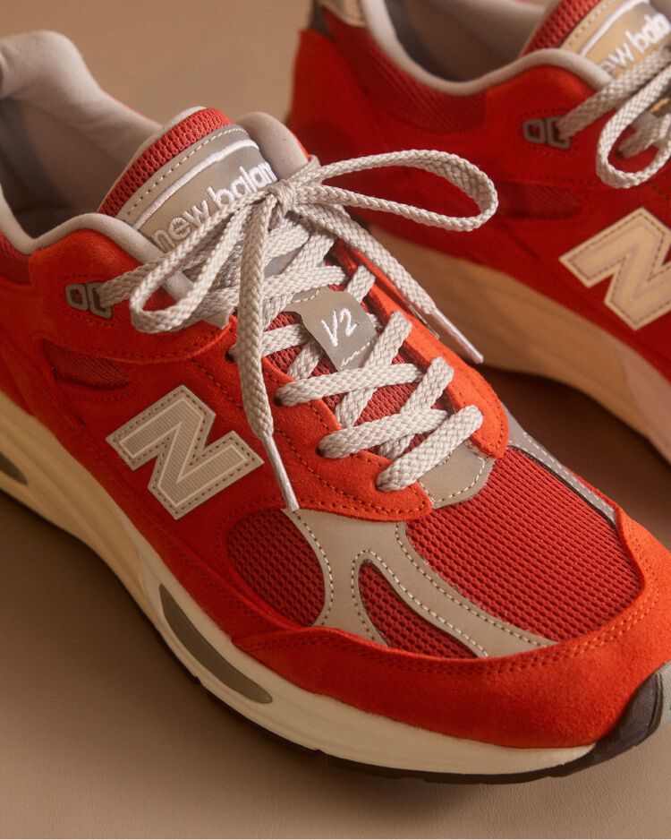 Primer plano de un par de zapatillas New Balance Made in UK en un estudio de color beige.&nbsp;