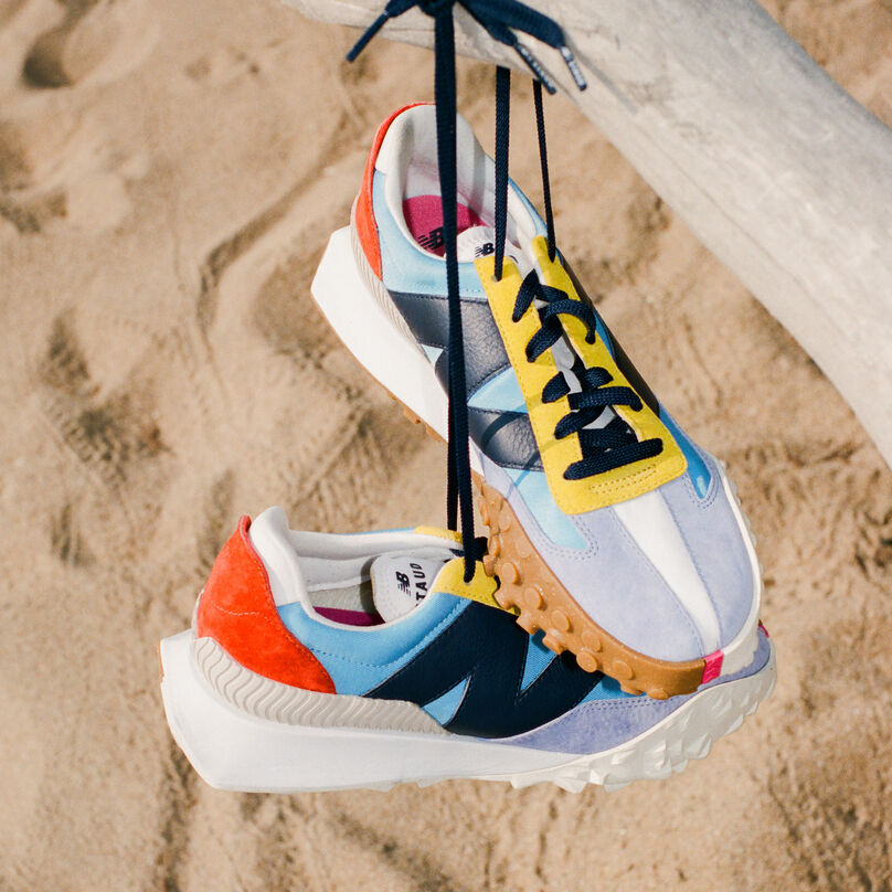 A pair of color blocked XC-72 shoes hanging from a branch